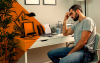 Imagem de um homem triste em sua mesa de trabalho