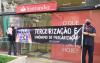 Dirigentes sindicais em frente a uma agência do Santander paralisada em protesto contra a reestruturação promovida pelo banco. Eles seguram uma faixa onde se lê: "Tercerização é sinônimo de precarização"