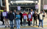 Dirigentes sindicais posam com cartazes de protesto em frente ao Bank of China