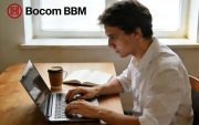 Imagem mostra um homem jovem, branco e de cabelos curtos trabalhando em um computador